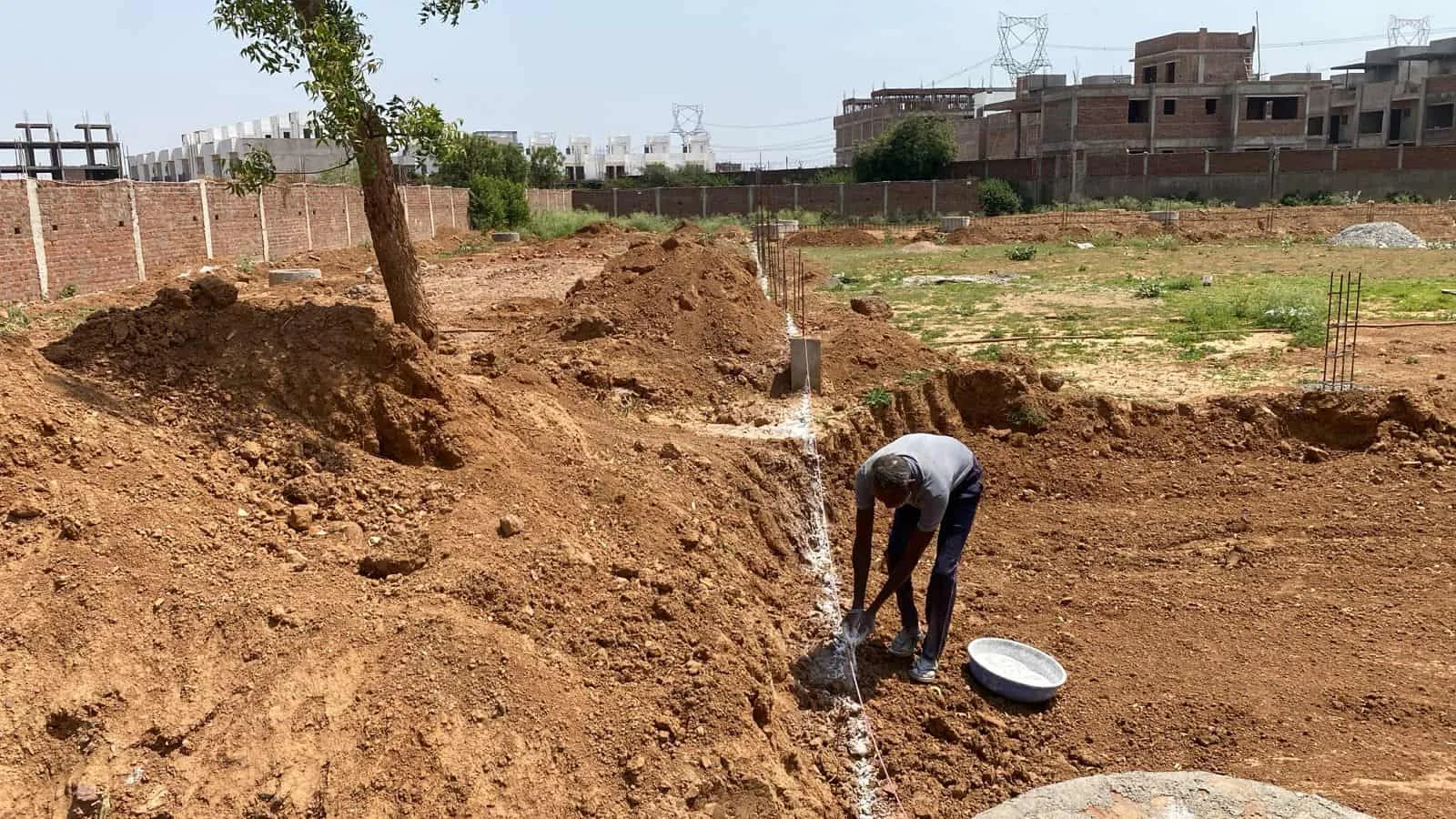 Construction worker installing underground water pipe system.