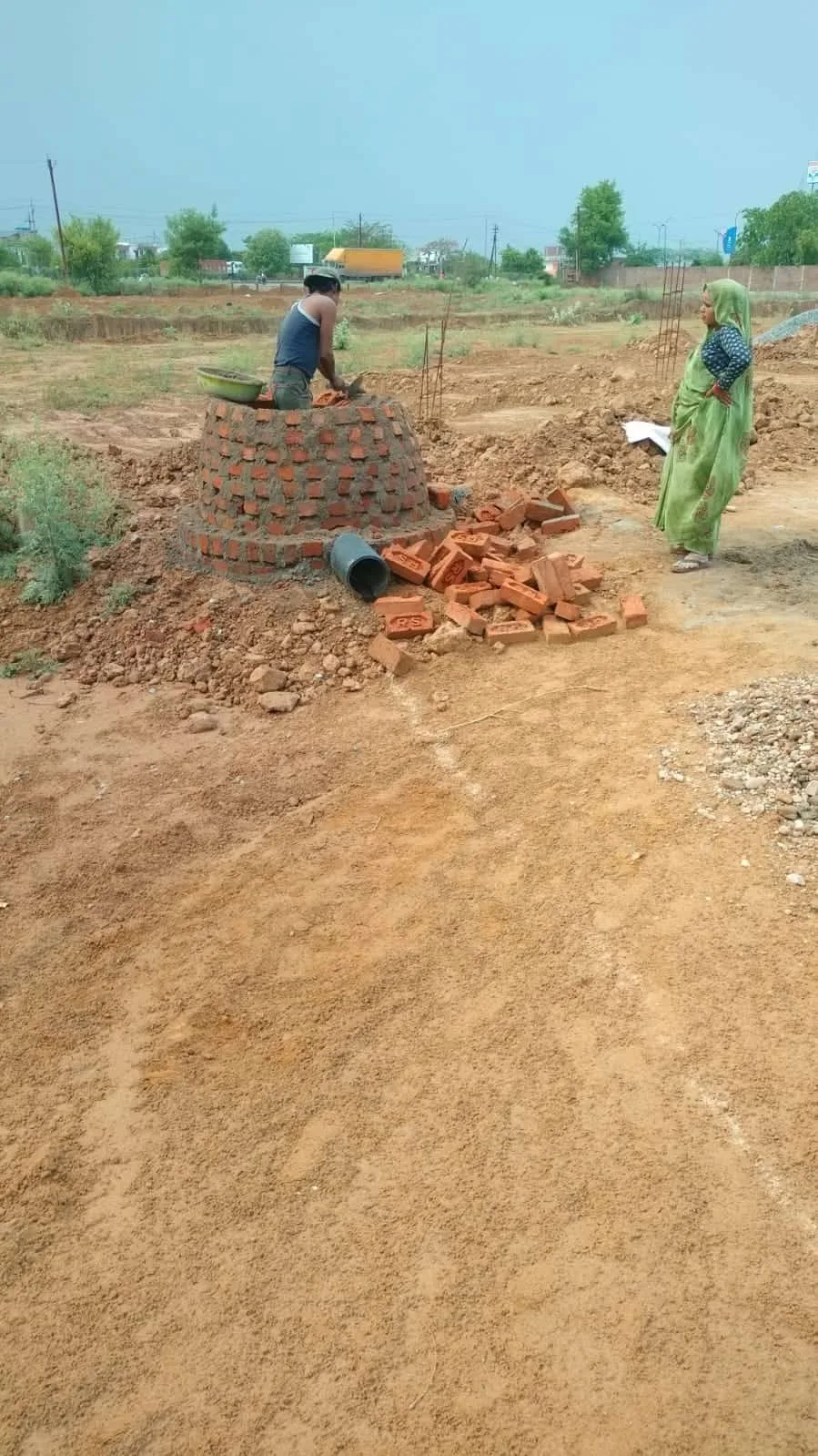 Bricklayer building a small brick wall with clay bricks and mortar.